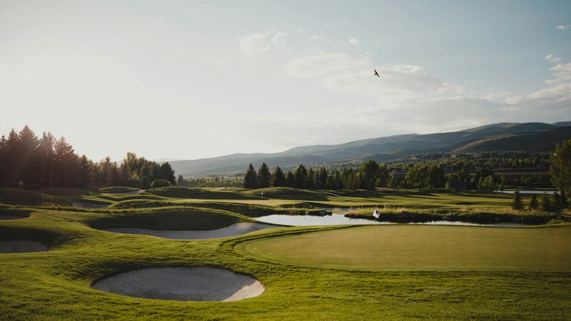 A wide course in a river valley, low sun, hills closing the far end.